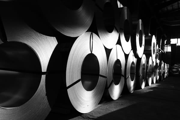 Rolls of steel lined up in an industrial supply warehouse